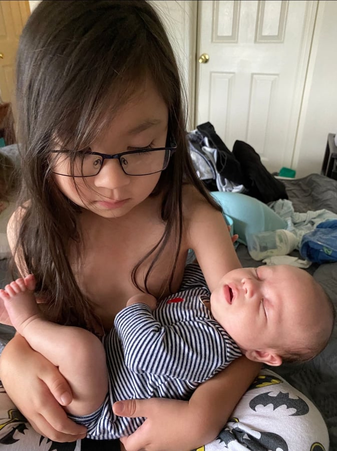 photo of a big brother rocking his baby brother to sleep
