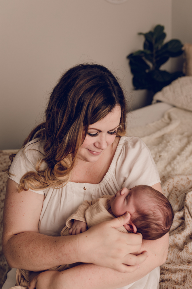 Mom holding a newborn baby boy during a newborn photography session
