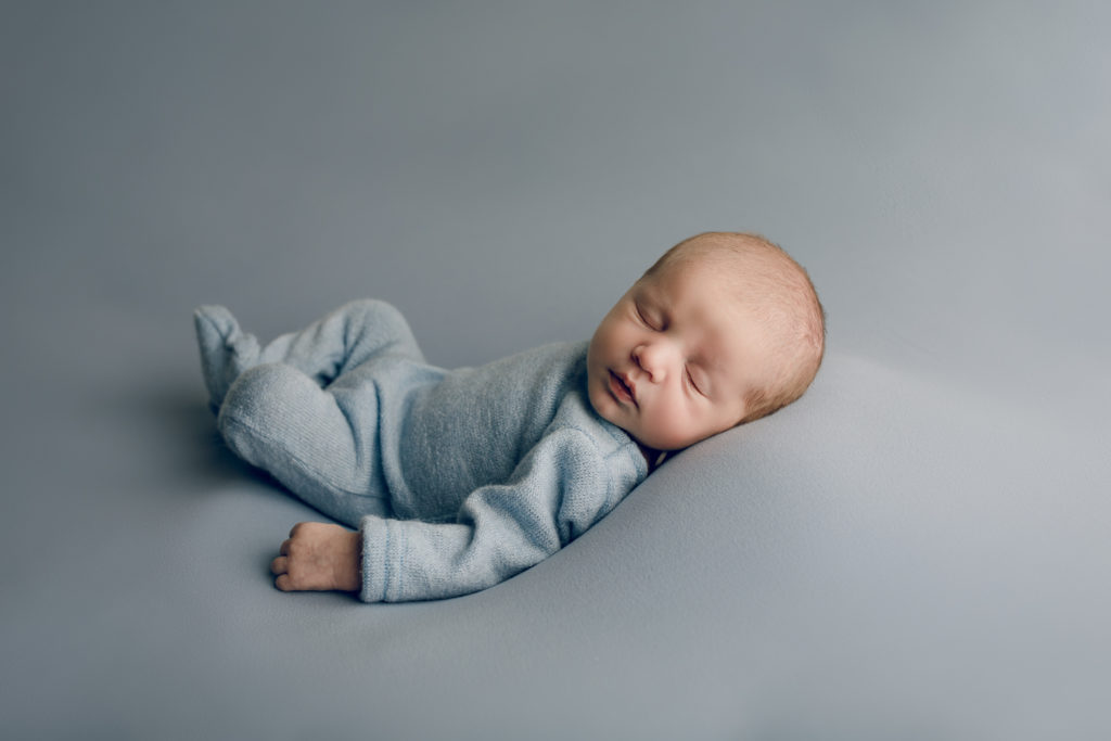 Baby boy wearing blue during a newborn photography session
