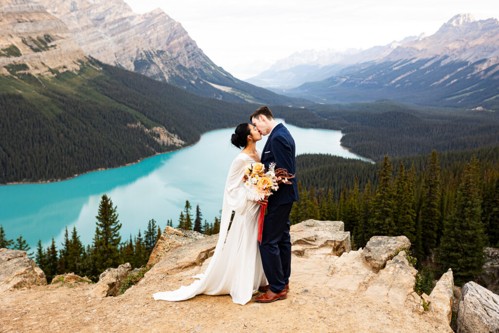 Couple sharing a first kiss after their elopement ceremony at a Banff lake.